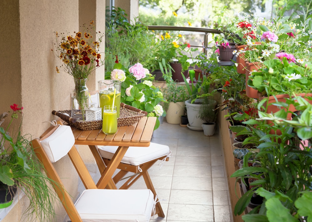 balcon végétal avec petite table et chaises en bois