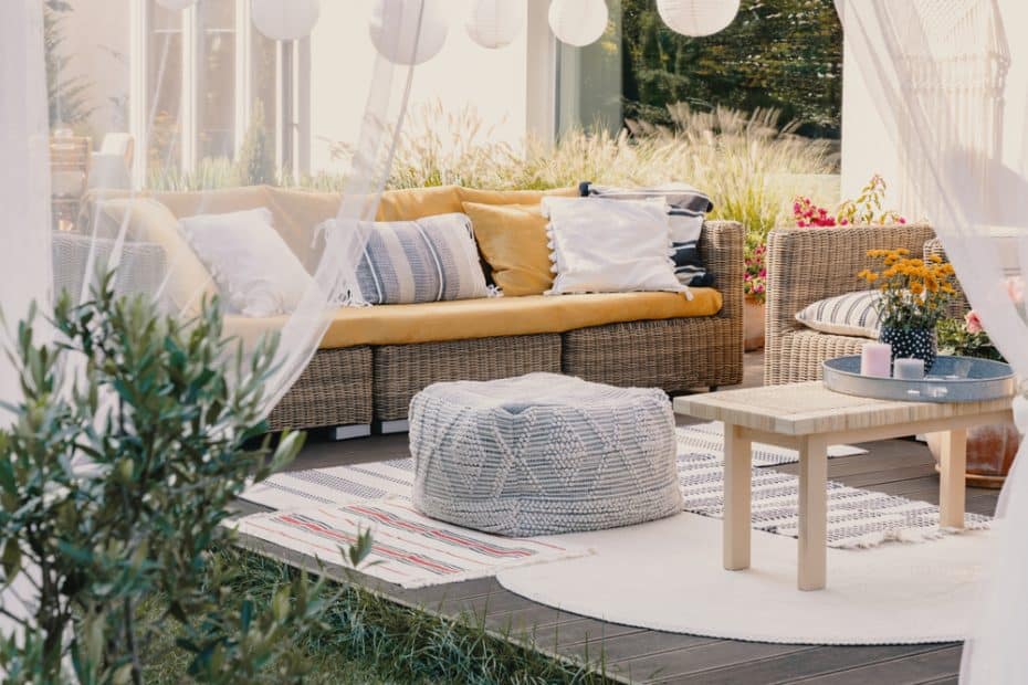 terrasse design avec tapis outdoor et coussins colorés sur canapé