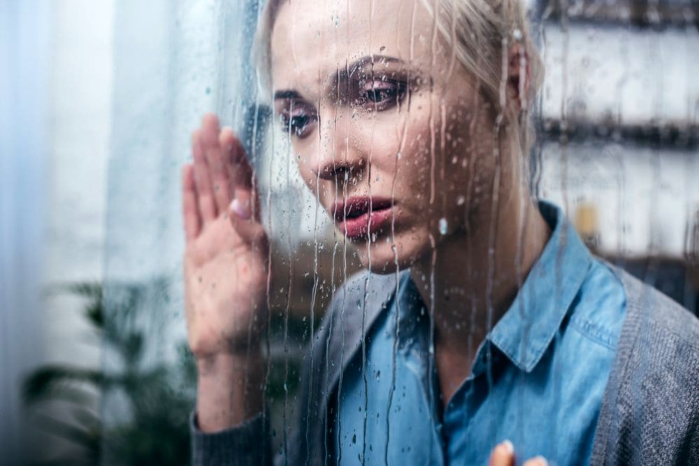 Une femme qui déprime sous la pluie