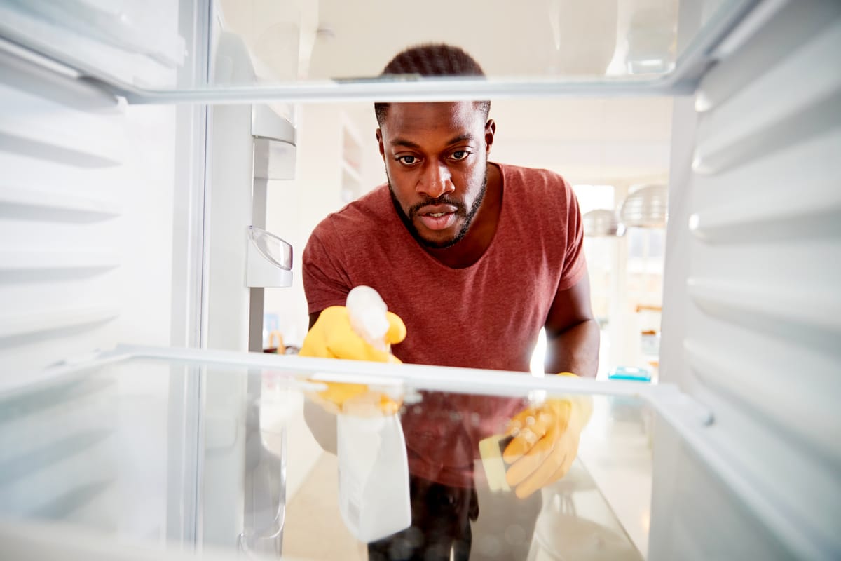  Homme nettoyant l'intérieur du frigo