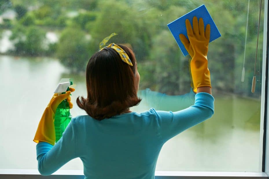 Femme nettoie les vitres avec un chiffon