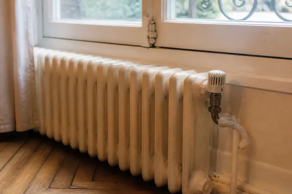 Radiateur en fonte sous une fenetre, vanne thermostatique
